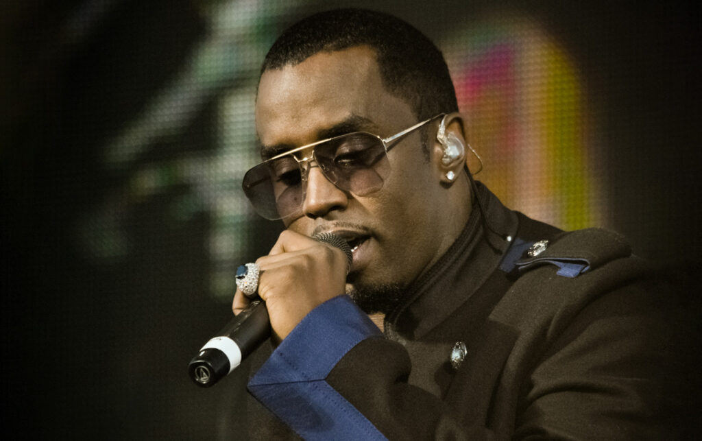 Sean Combs with microphone in hand rapping.