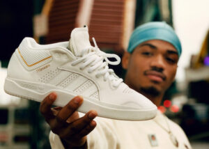 Photo of Tyshawn Jones (TJ) holding up his branded sneaker with Adidas