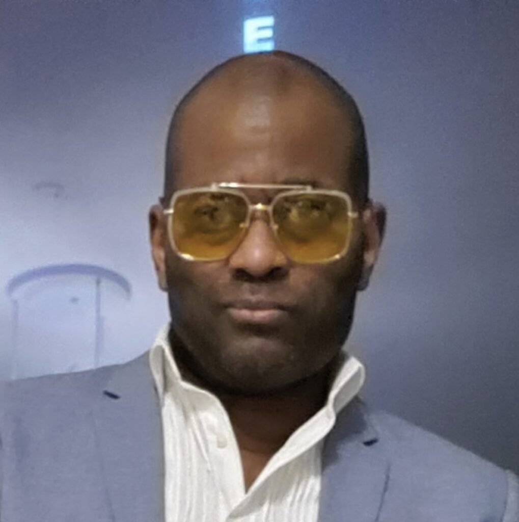 Photo of Chaka Wilson in a suit with glasses